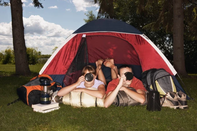 Couple in tent drinking from mugs